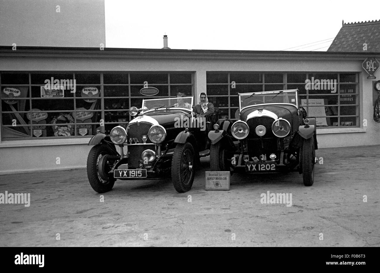 Zwei Frauen sitzen im hinteren Teil ein Bentley Auto neben einem anderen Bentley außerhalb einer garage Stockfoto