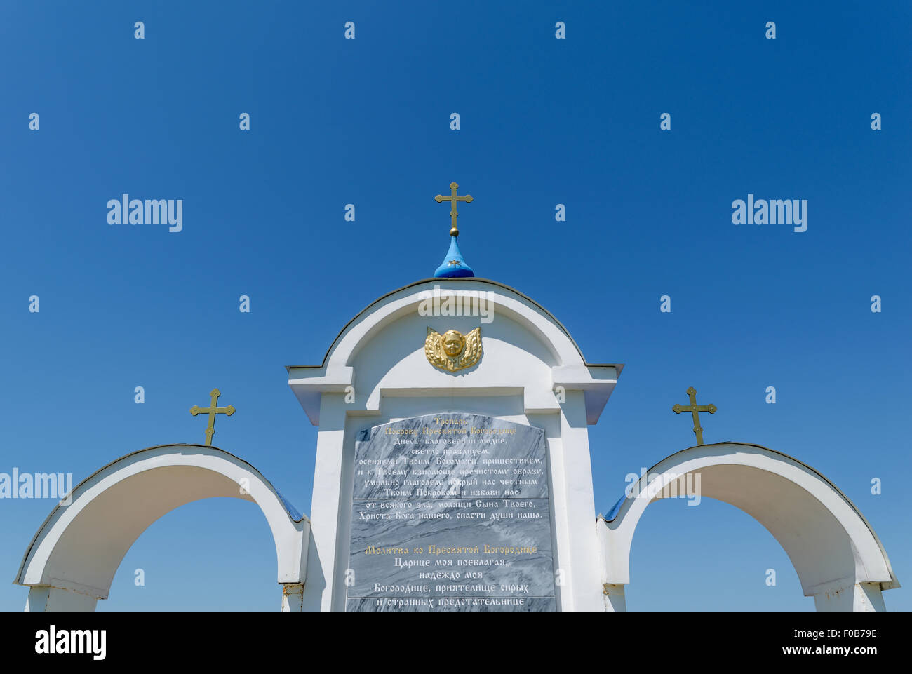 Fragment eines Gebets der Heiligen Mutter Gottes, eingraviert auf dem weißen Trikuspidalklappe Bogen mit orthodoxen Kreuze drüber Stockfoto