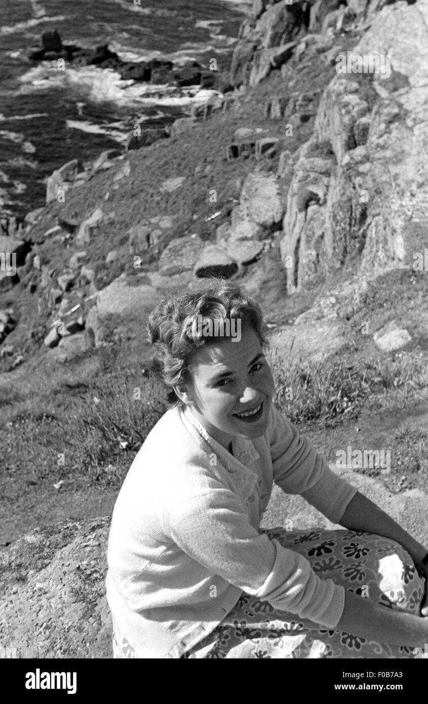 Junge Dame sitzen auf den Felsen am Meer. Stockfoto