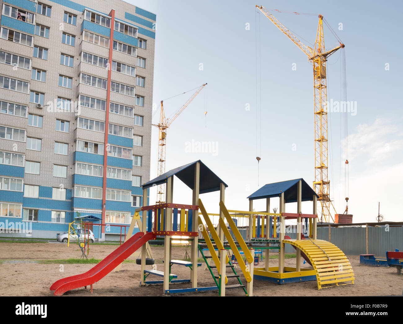 Baukran und ein Spielplatz im Hof Stockfoto