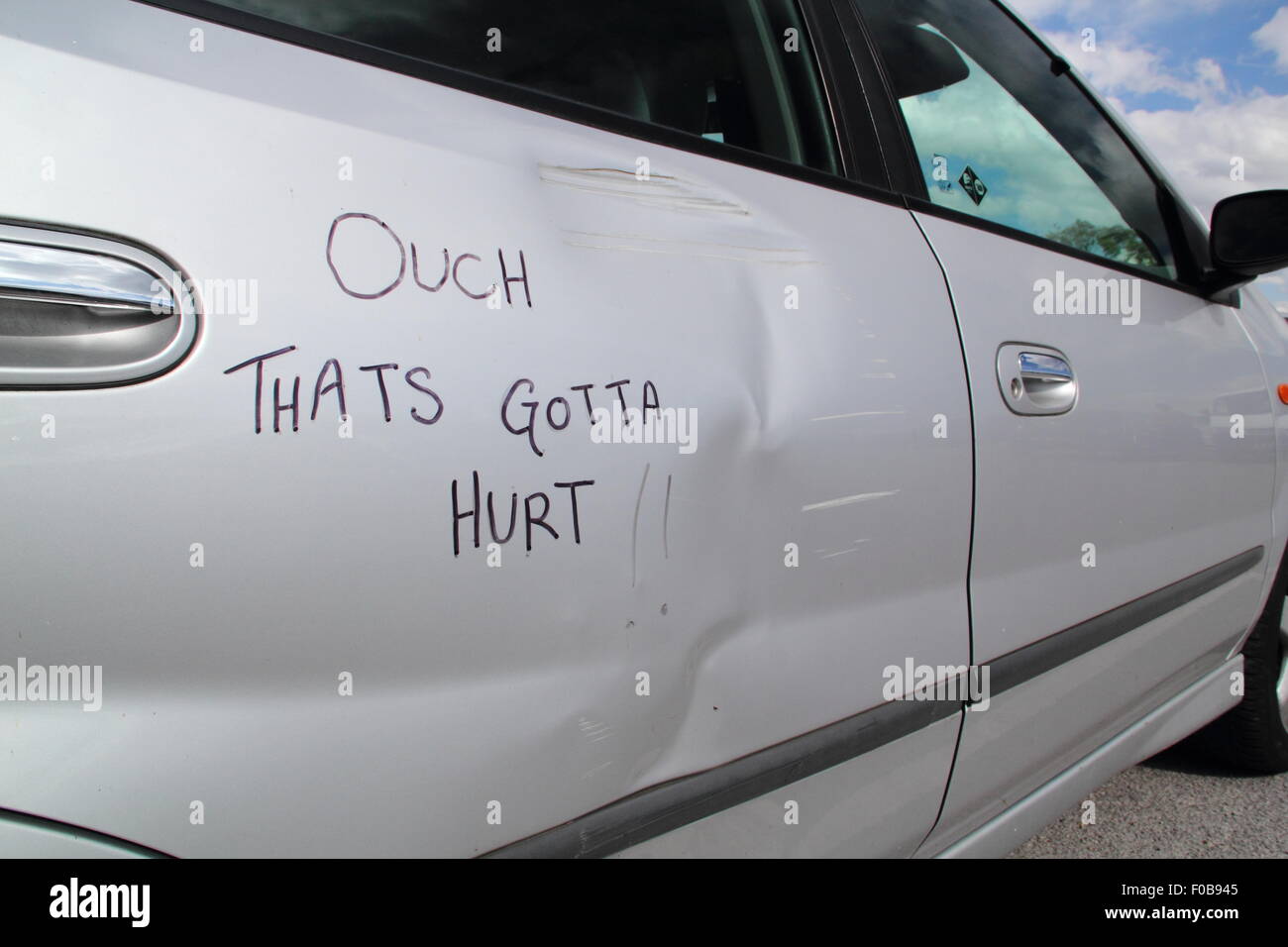 Ein beschädigtes Auto ist mit der Aufschrift "Autsch - das ist gotta Hurt; England Großbritannien Stockfoto