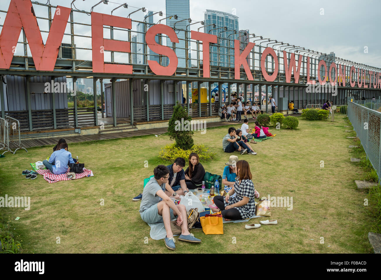 Menschen sitzen auf dem Rasen im West Kowloon Park in Hong Kong Stockfoto