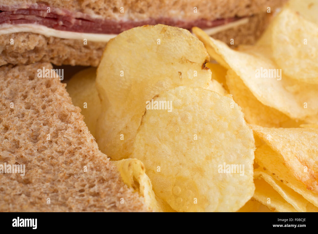 Blick auf ein Roast Beef Weizenbrot Sandwich mit Käse und Mayonnaise sowie Kartoffelchips zu schließen. Stockfoto