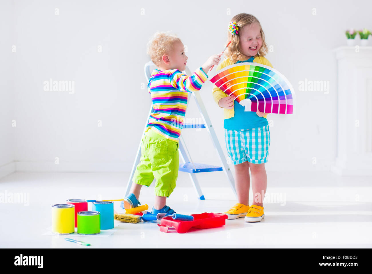 Familie das Haus umgestaltet. Haus renovieren und sanieren. Kinder malen Wände mit bunten Pinsel und Rolle. Stockfoto