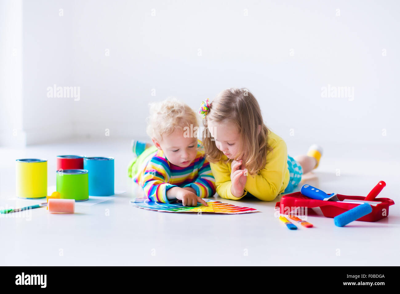 Familie das Haus umgestaltet. Haus renovieren und sanieren. Kinder malen Wände mit bunten Pinsel und Rolle. Stockfoto