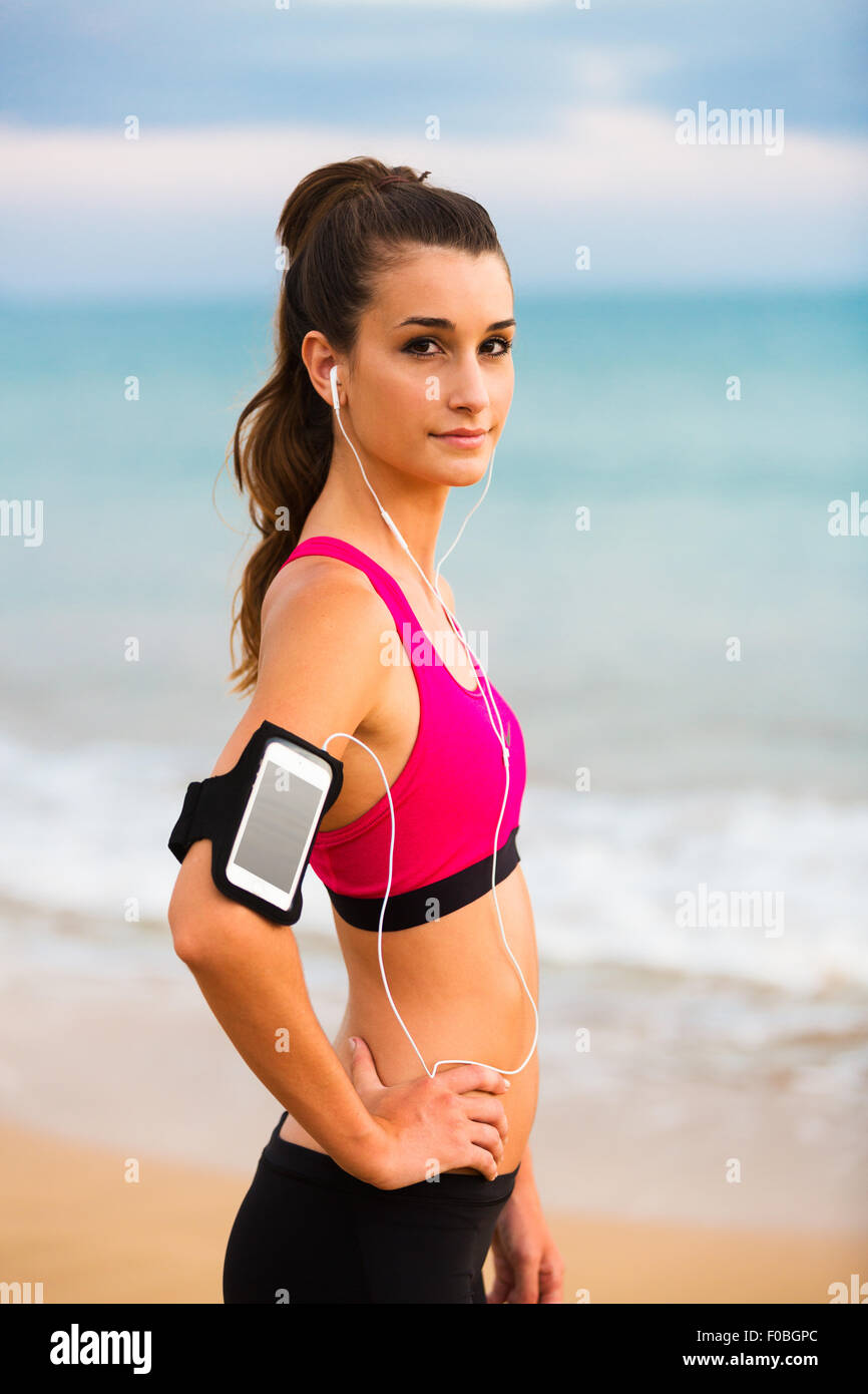 Junge Fitness Frau mit Smartphone Ready for Training. Fitness-Technologie-Konzept. Stockfoto