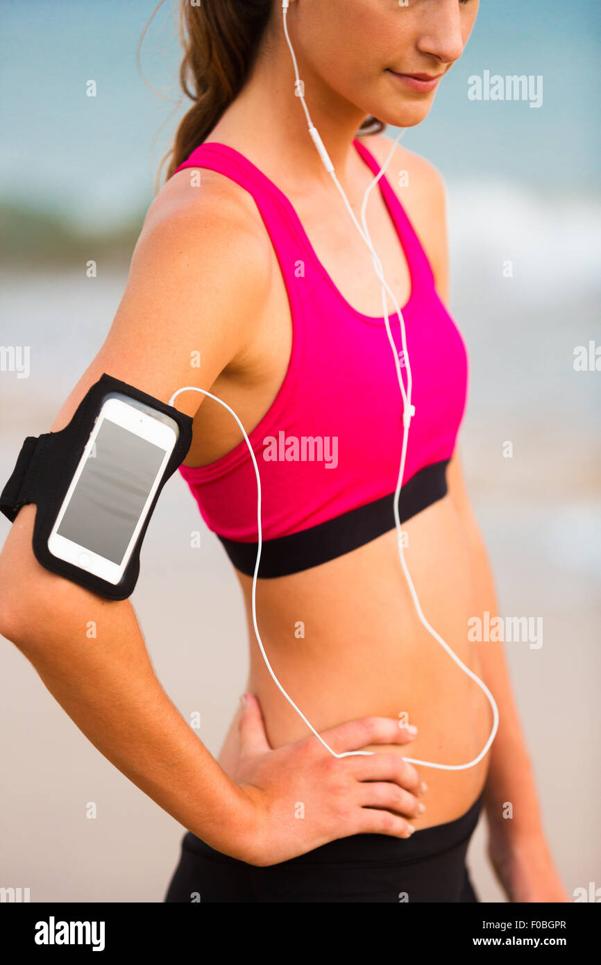 Junge Fitness Frau mit Smartphone Ready for Training. Fitness-Technologie-Konzept. Stockfoto