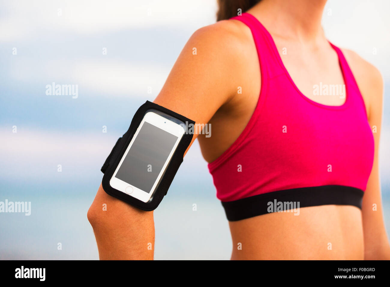 Junge Fitness Frau mit Smartphone Ready for Training. Fitness-Technologie-Konzept. Stockfoto