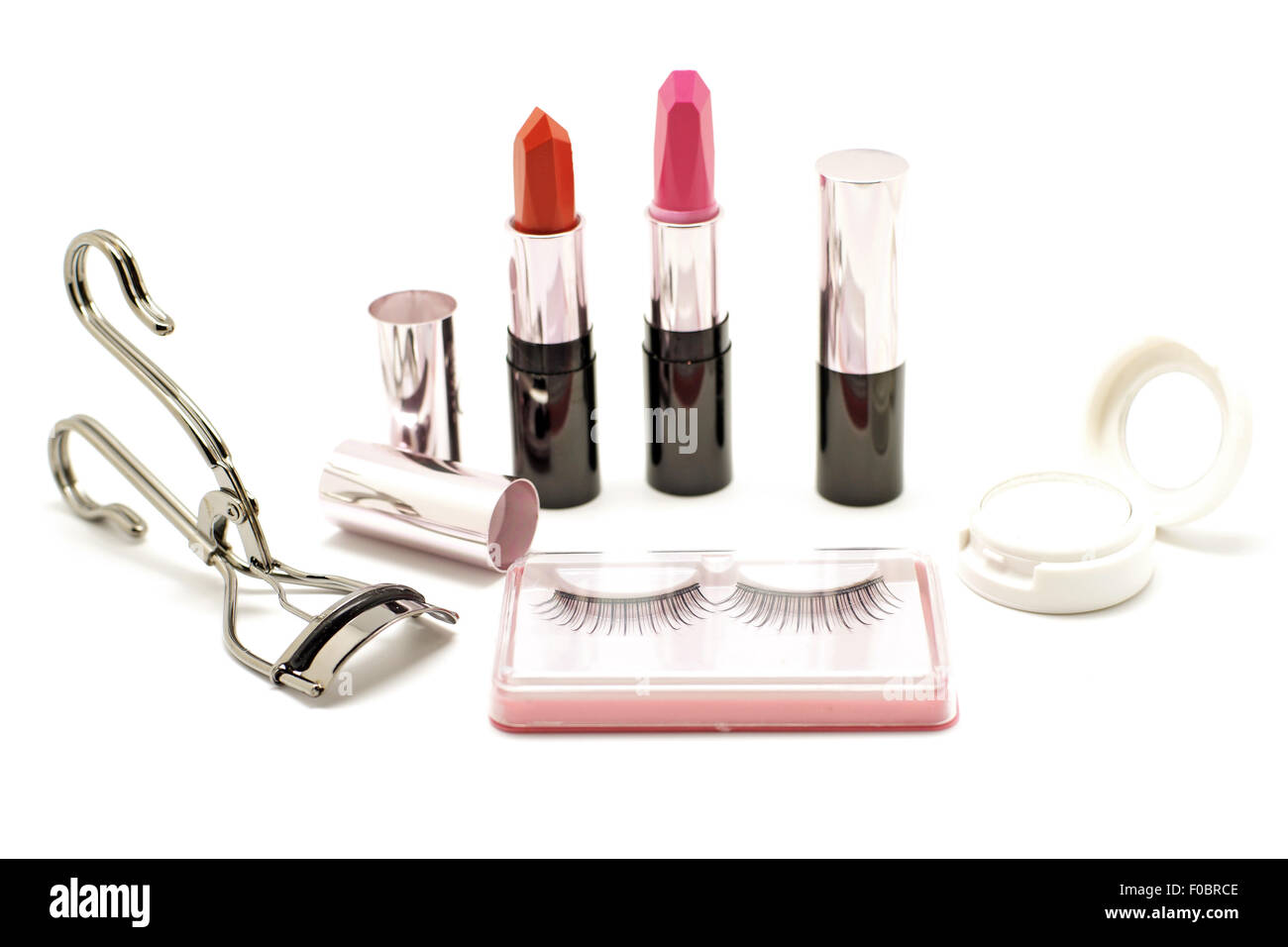 Make-up set mit Wimpernzange Lippenstift falsche Wimpern und Lidschatten isoliert auf weißem Hintergrund Stockfoto