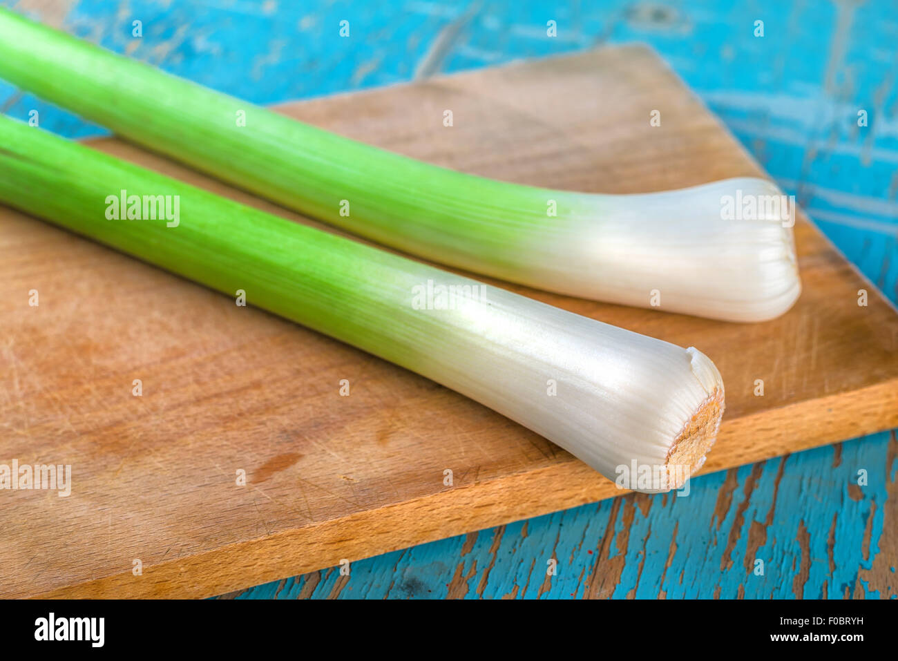 Lauch auf Schneidebrett auf rustikalen Holz Küchentisch, frisches grünes Gemüse für gesunde Ernährung Vorteile Stockfoto