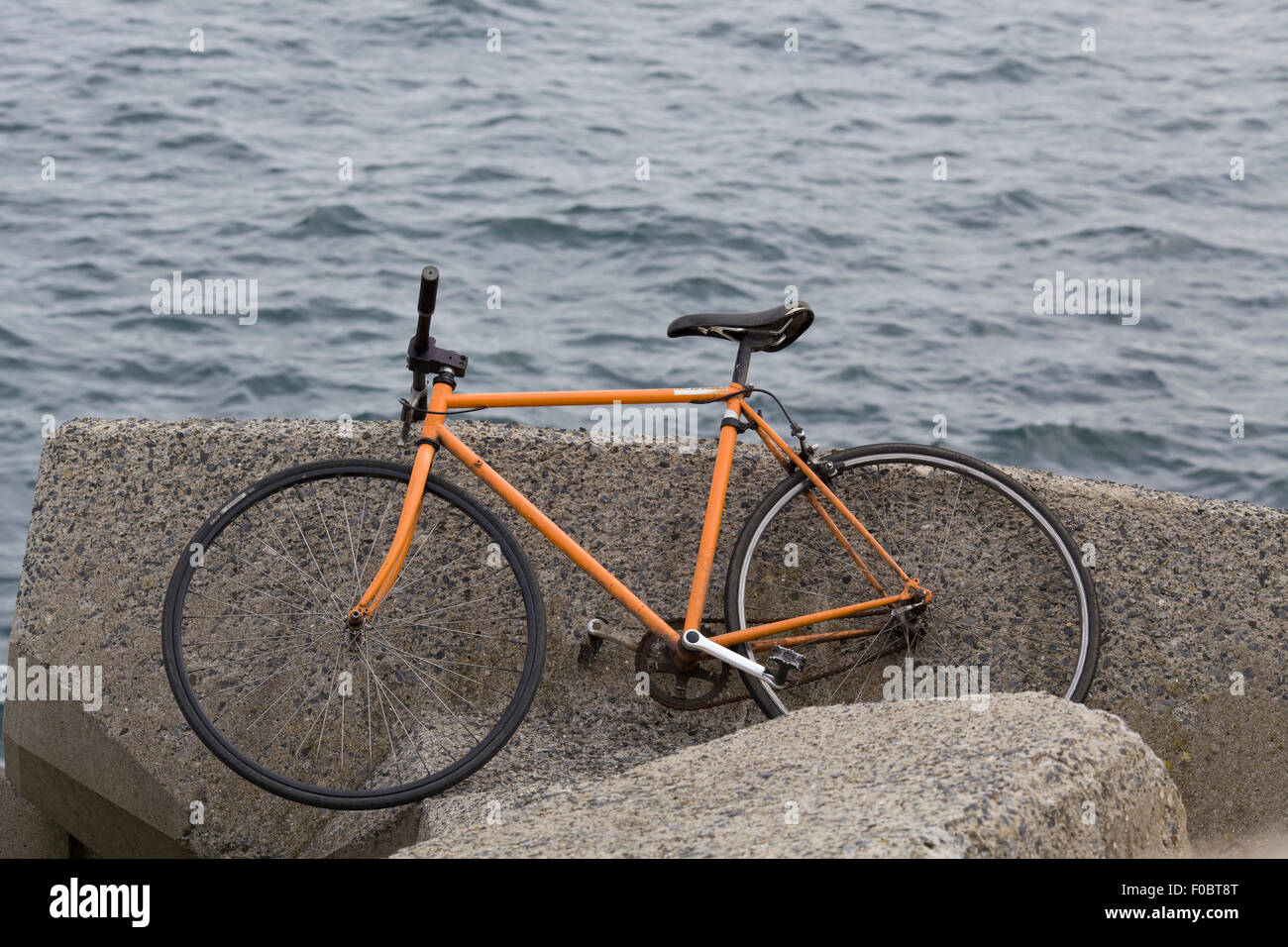Verlassene Fahrrad auf ein Sperrwerks über dem Ozean Stockfoto