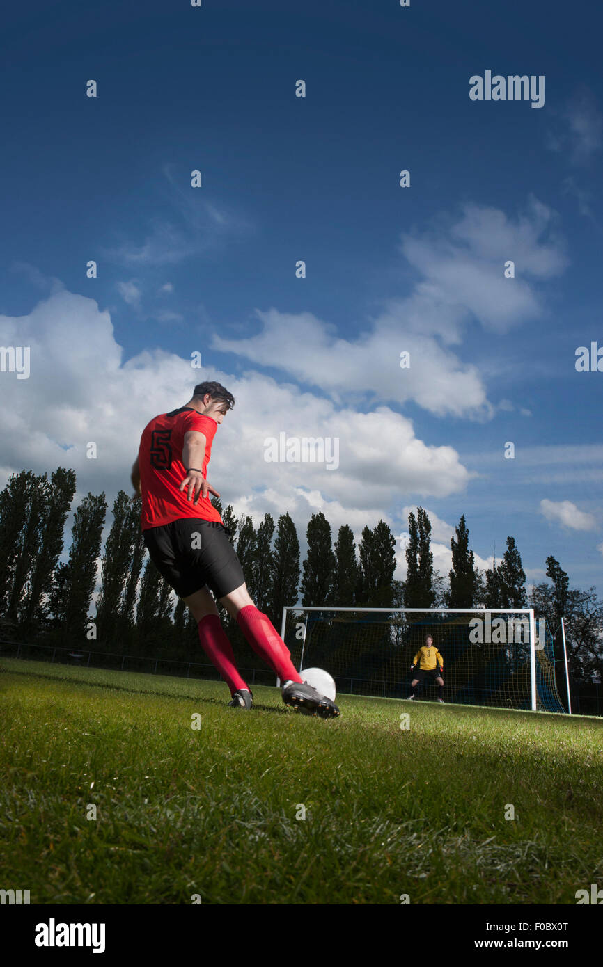 Voller Länge Fußballspielers treten Ball auf das Tor Stockfoto