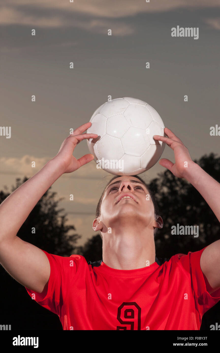Junge Fußballer Ausgleich Ball auf Kopf Stockfoto