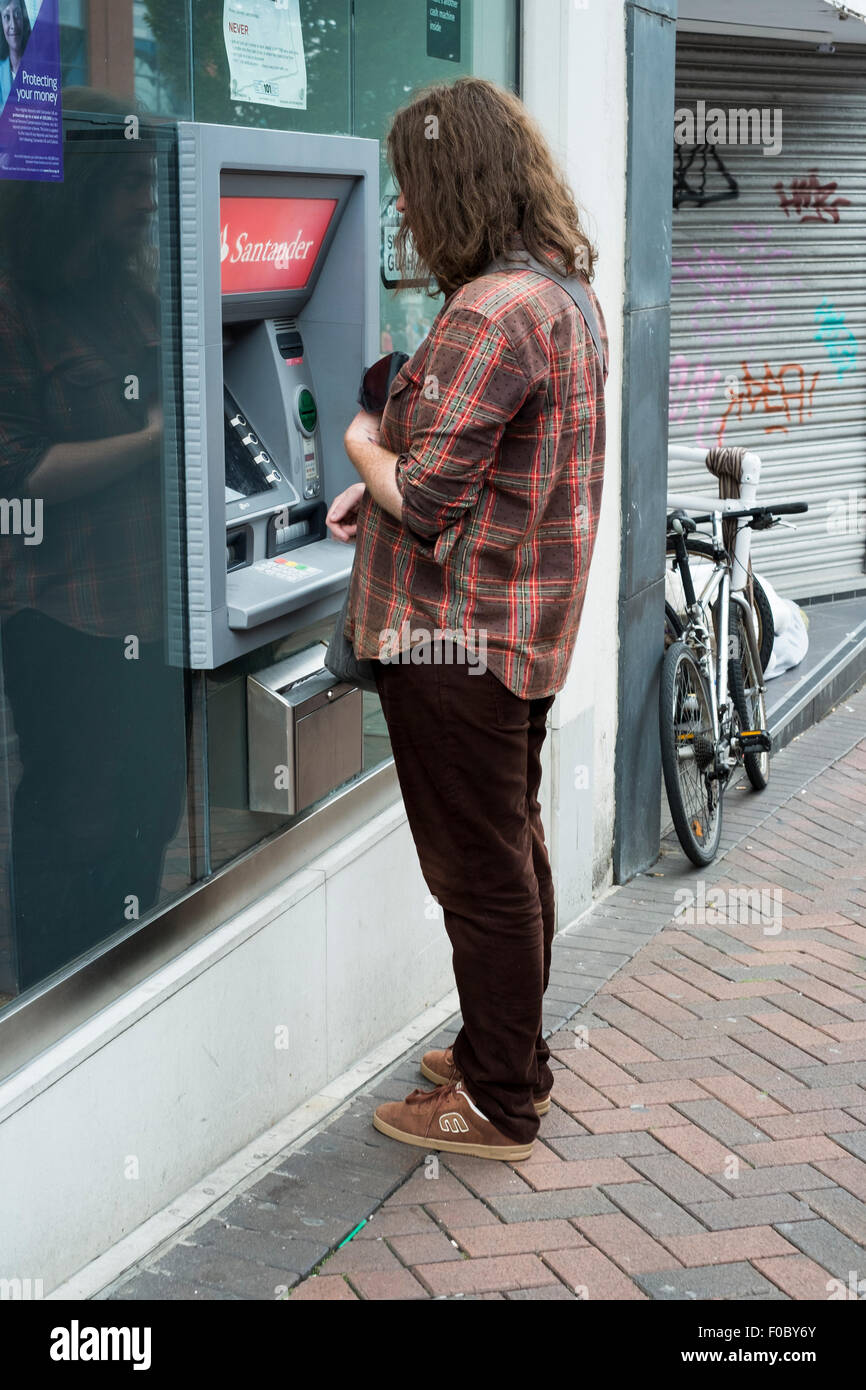 Frau bei einem Santander ATM in der Einkaufsstraße Stockfoto