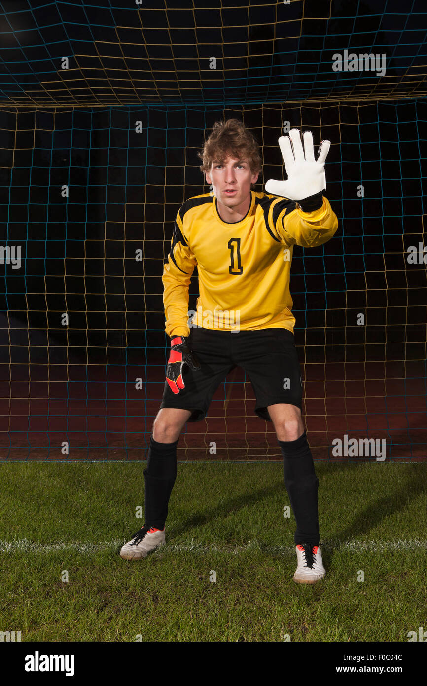 Porträt von zuversichtlich Torwart Verteidigung Fußballnetz auf Feld Stockfoto