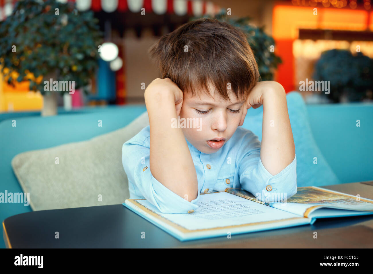 Langweilig und müde kleiner Junge Buch Stockfoto