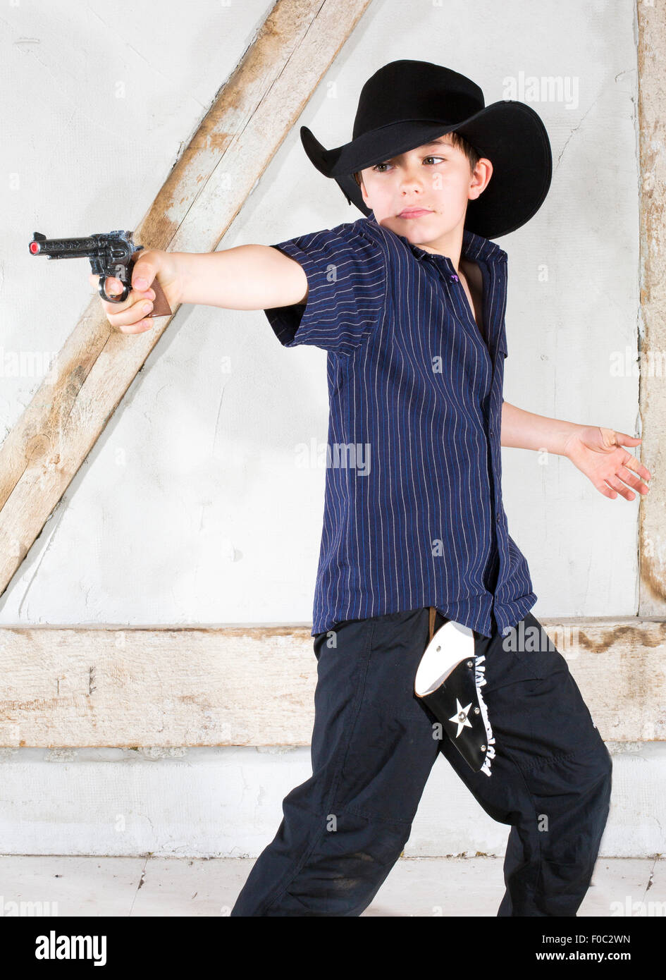 kleiner Junge gekleidet wie ein Cowboy mit Hut und Pistole Stockfoto