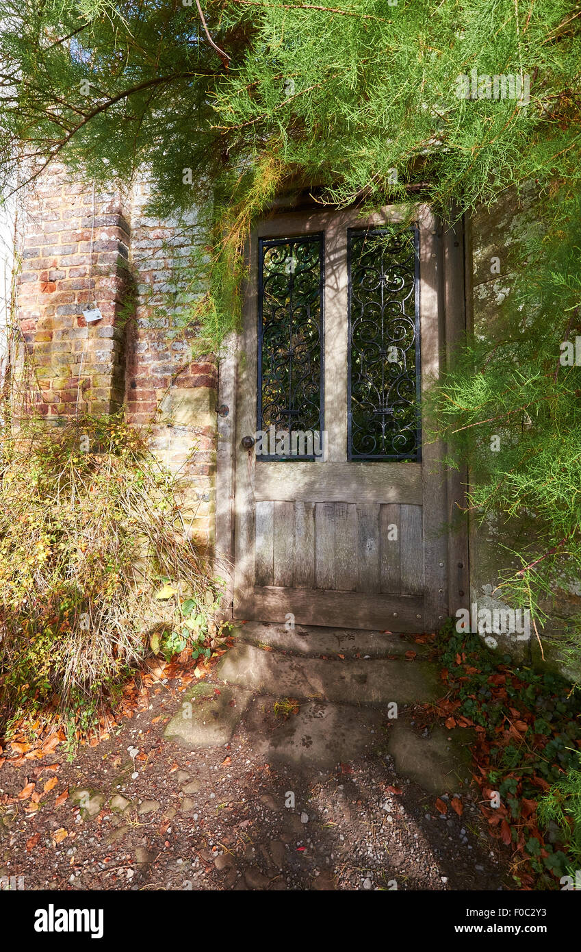 Eine Tür führt zu einem geheimen Garten in einem englischen Herrenhaus. Stockfoto