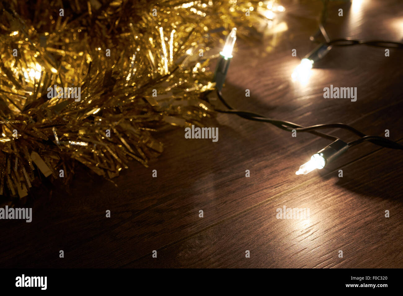 Traditionellen Weihnachtsbaum Lichter und Lametta liegend auf einem Holzfußboden. Stockfoto