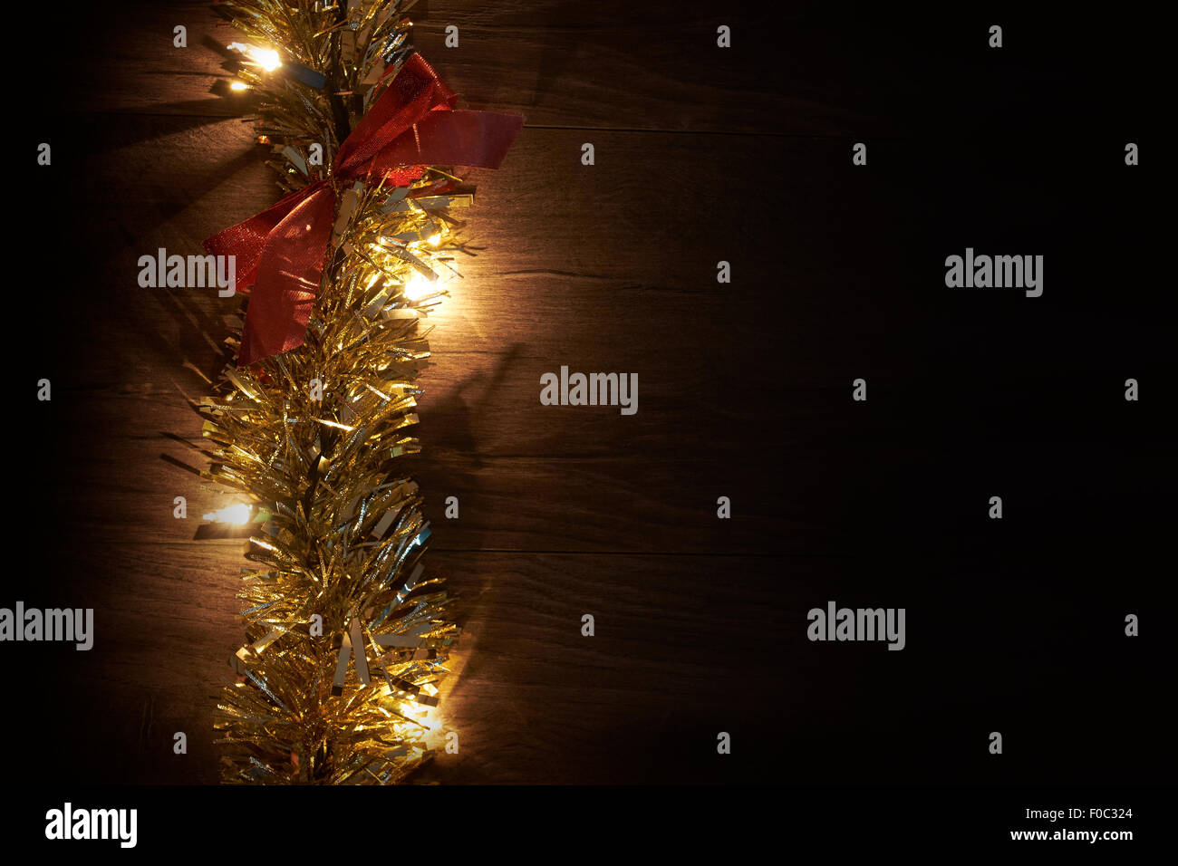 Traditionellen Weihnachtsbaum Lichter, Lametta und Farbband liegend auf einem Holzfußboden. Stockfoto