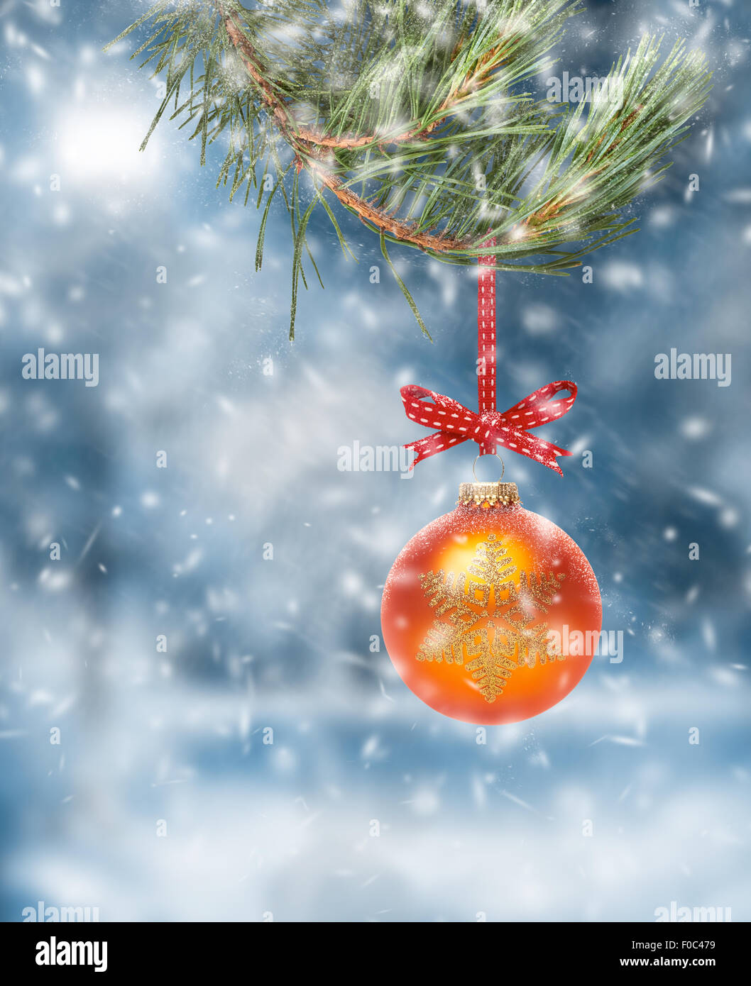 Traditionellen Weihnachtsbaum Dekoration hängen von einem Ast mit einem Schnee-Szene-Hintergrund. Stockfoto