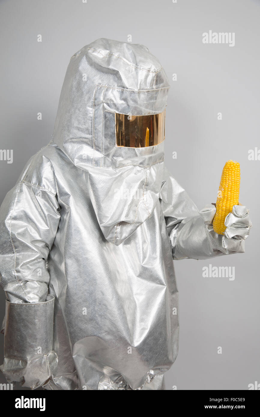 Eine Person in einer Strahlung Schutzanzug hält einen Maiskolben Stockfoto