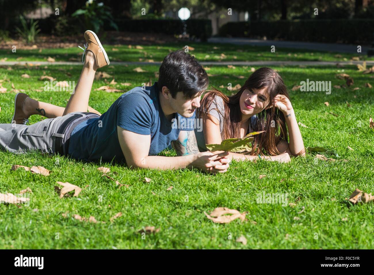 Junges Paar mit Herbst Blatt im Park liegen Stockfoto