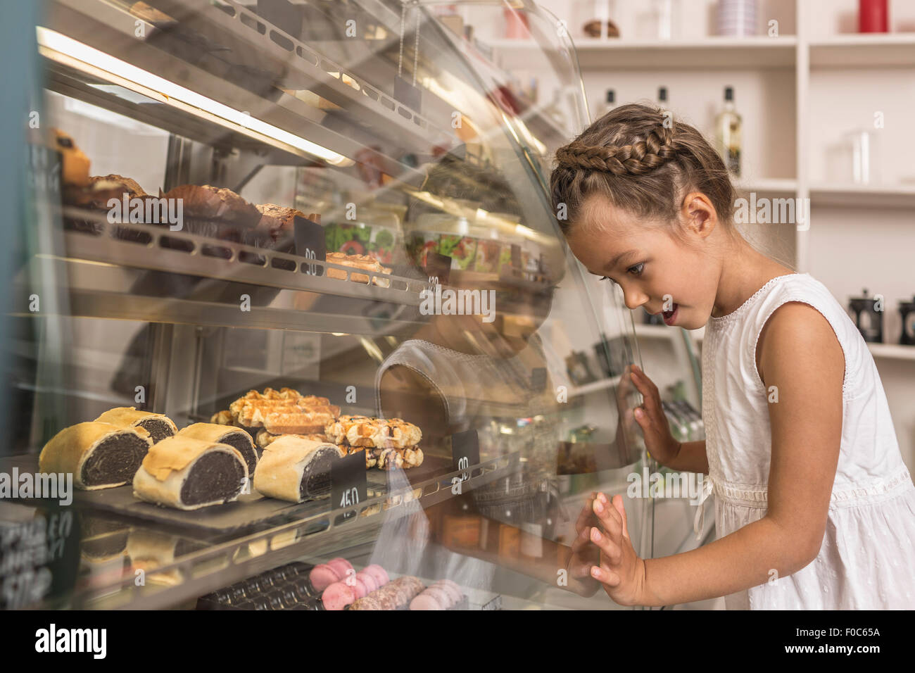 Seitenansicht des Mädchens bewundern Dessert in Bäckerei Stockfoto