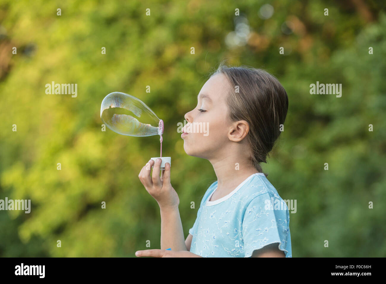 Seitenansicht des Mädchens Seifenblase im freien Stockfoto