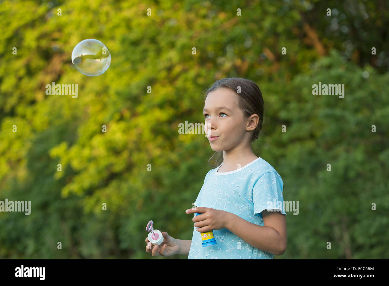 Glückliches Mädchen bläst Blase im freien Stockfoto