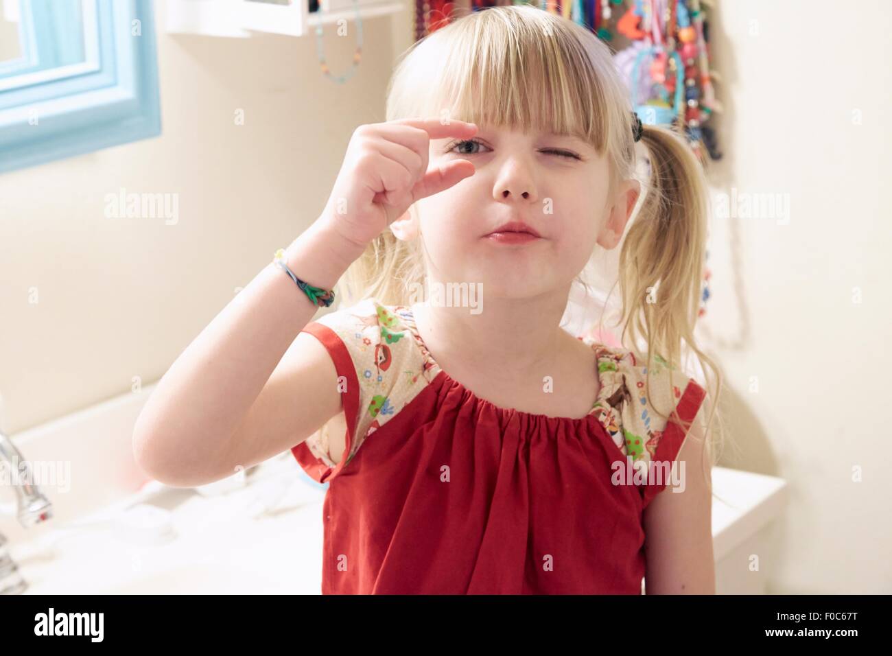 Porträt des jungen Mädchens, auf der Suche durch Finger Stockfoto