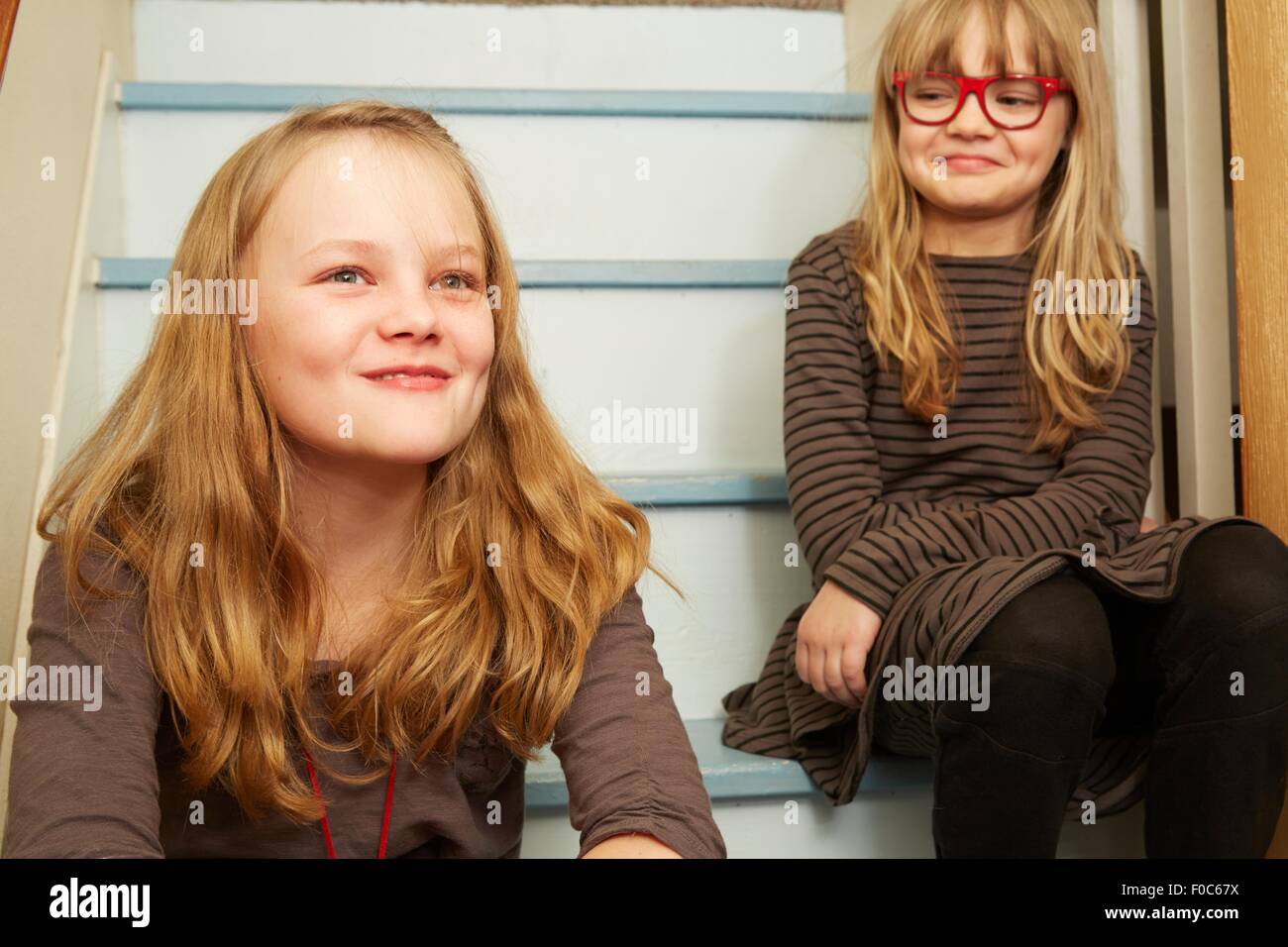 Zwei Schwestern sitzen auf Treppen, Lächeln Stockfoto
