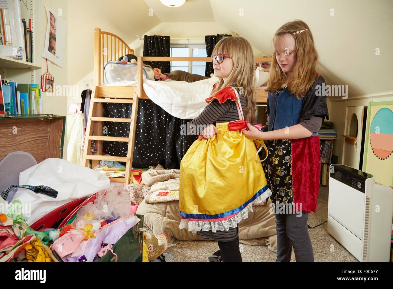 Zwei Schwestern spielen Anzieh, einer hilft dem anderen Kleid befestigen Stockfoto