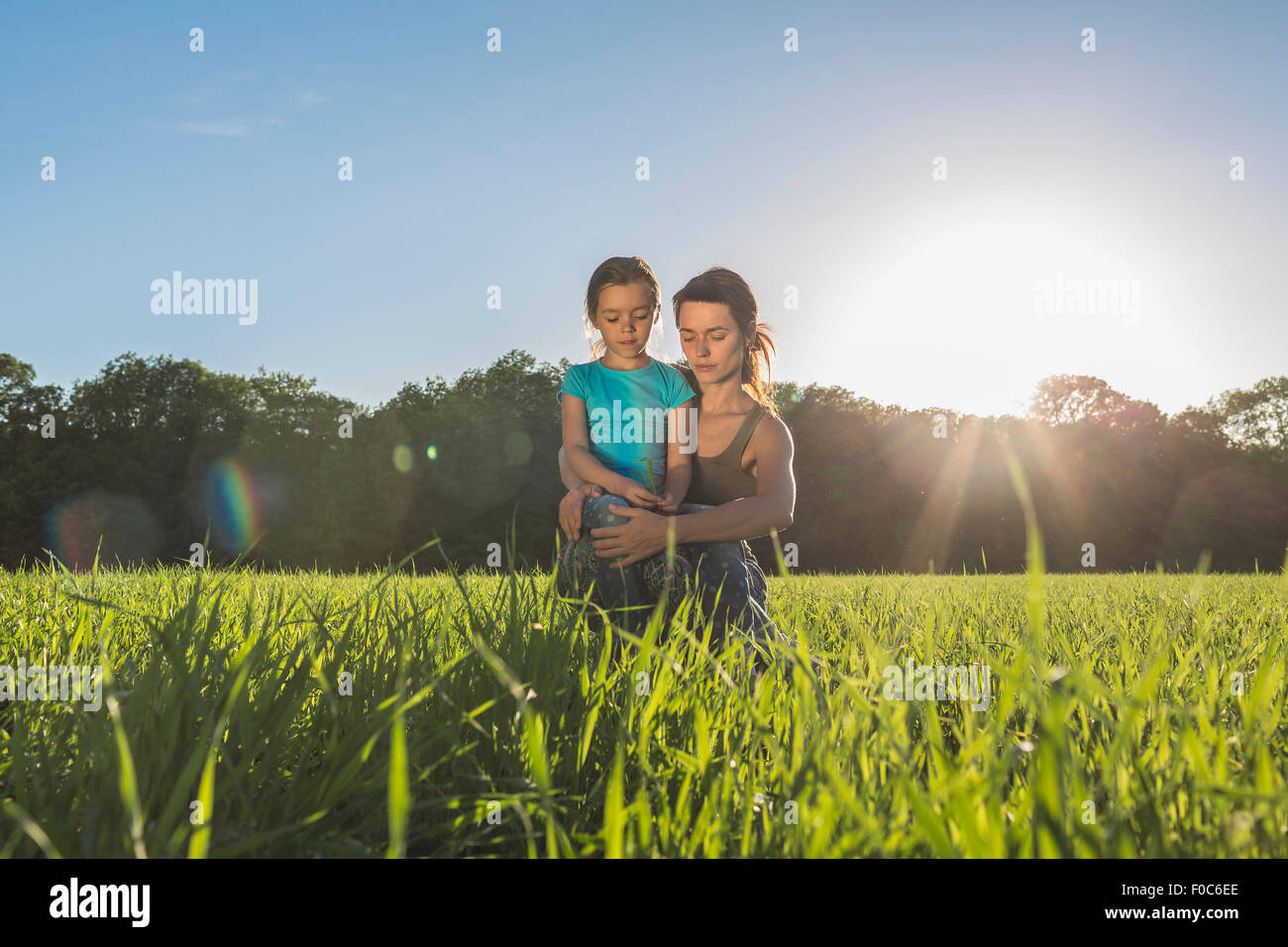 Mutter und Tochter sitzen auf der Wiese Stockfoto