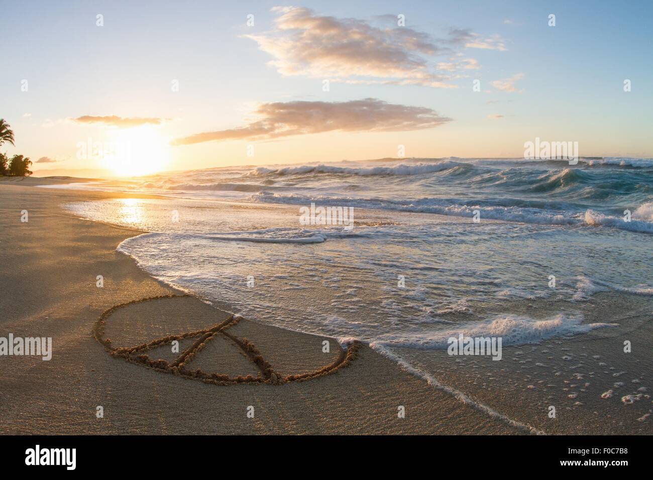 Friedenssymbol in Sand, Sonnenuntergang gezeichnet Stockfoto