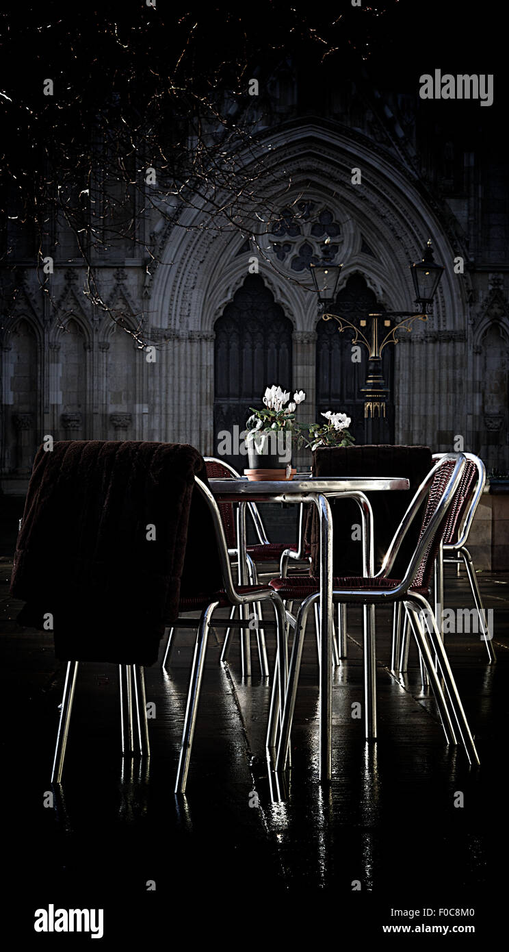 Stühle in einem Straßencafé sind kurz vor dem Sturm in York, England, mit York Minster im Hintergrund gesehen. Stockfoto