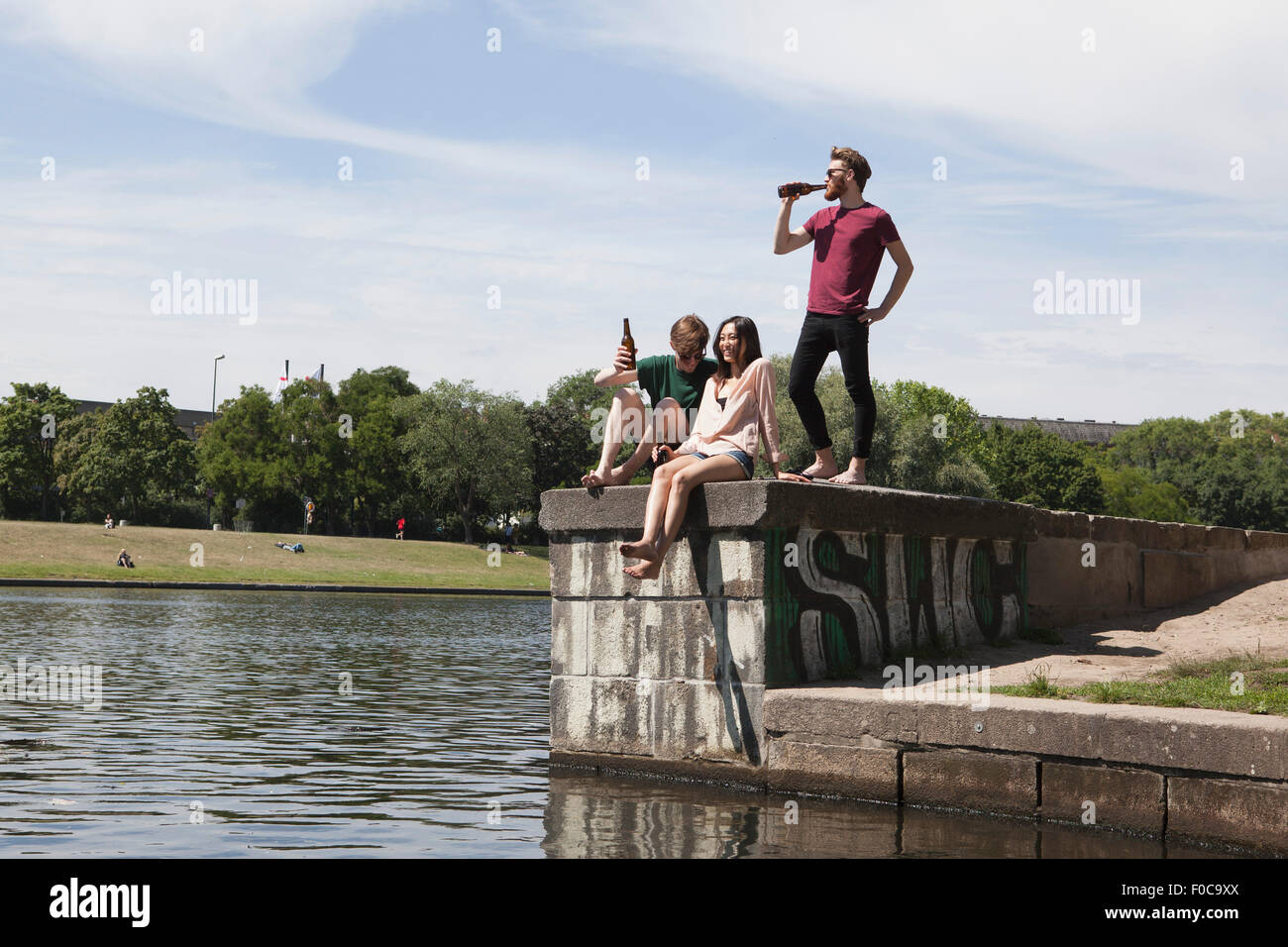 Multi-ethnischen Freunde genießen auf Stützmauer Kanal Stockfoto