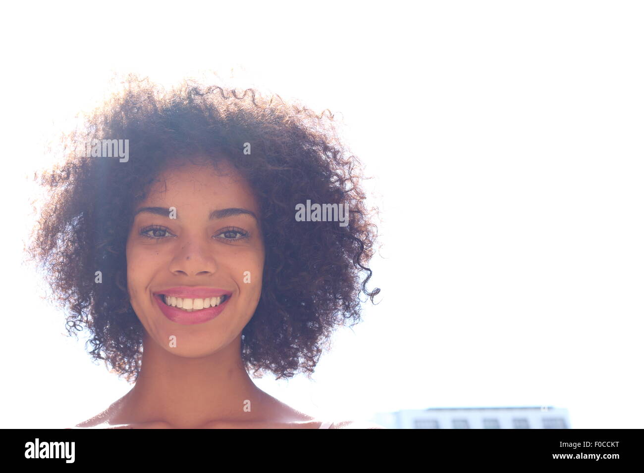 Glücklich schwarze Frau im Freien mit Objektiv flare in ihr afro Stockfoto