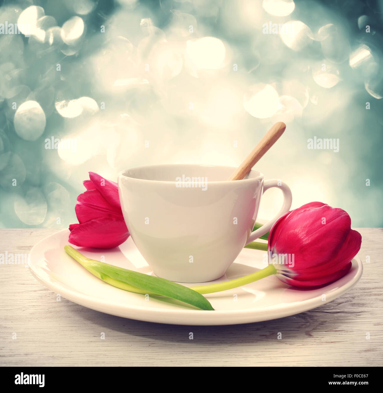 Kaffeetasse mit roten Tulpen über blau glänzenden Hintergrund Stockfoto