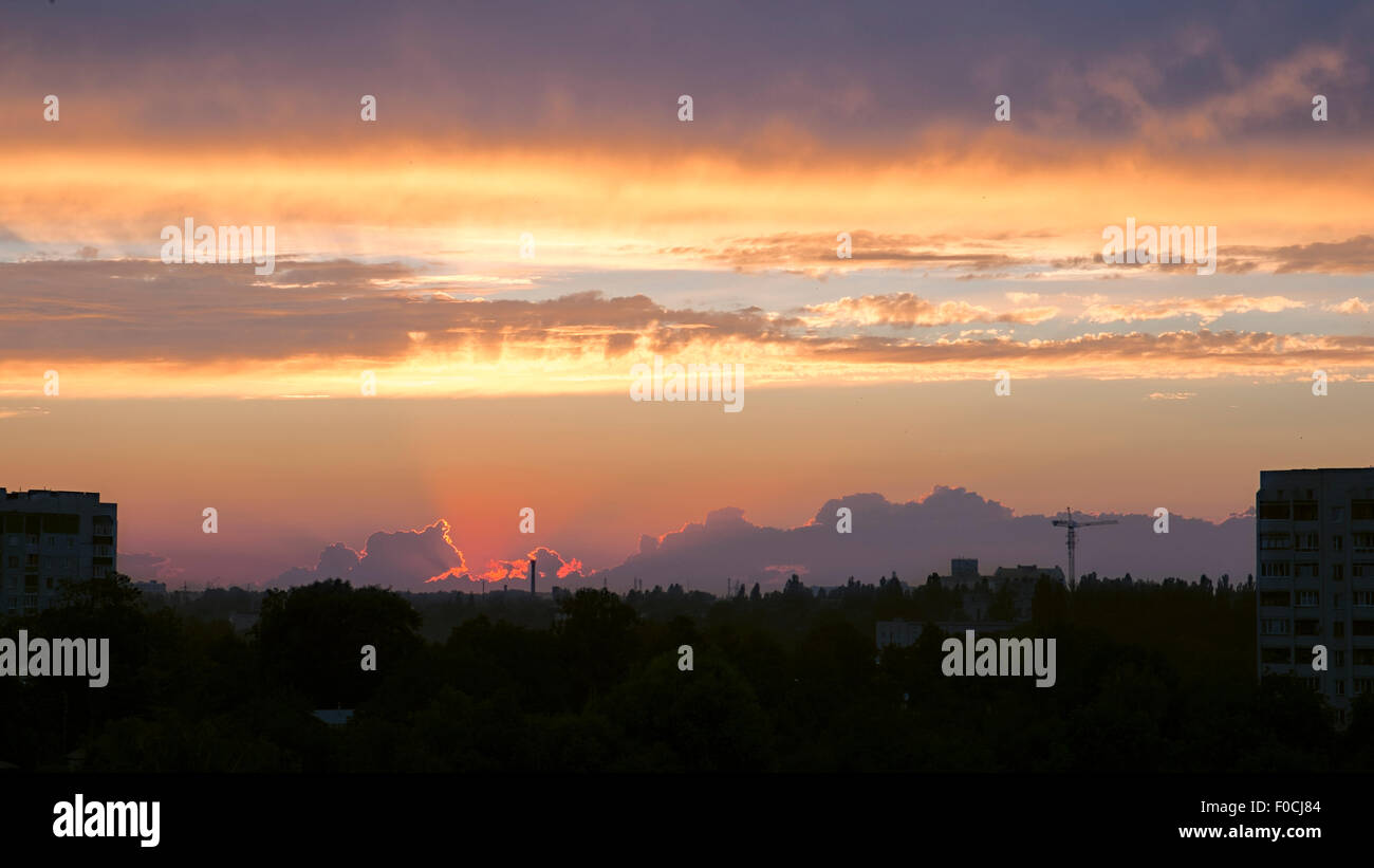 Sonnenuntergang in Wolken über Stadtbild Stockfoto