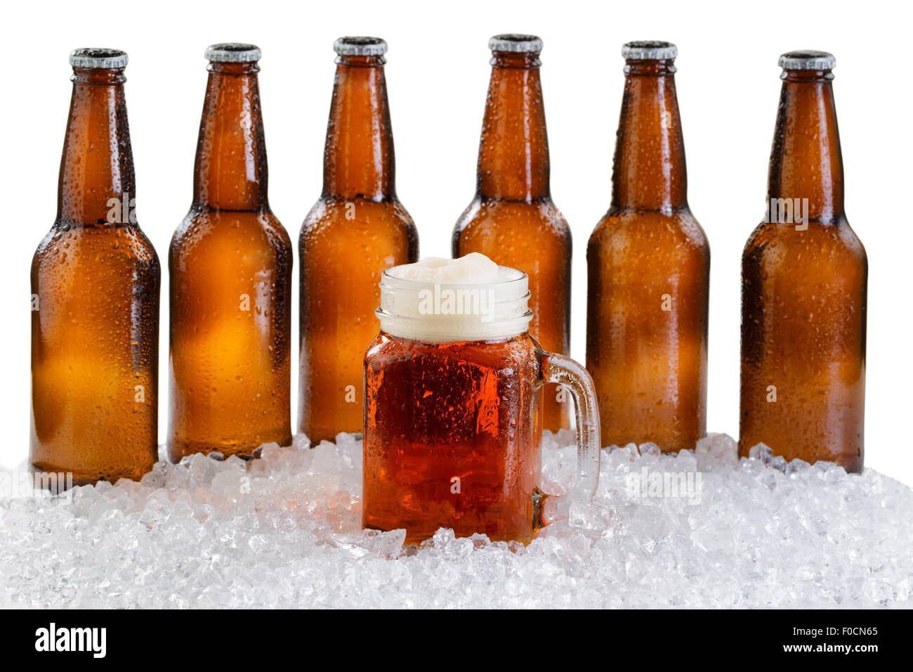 Milchglas Krug Bier vor ein six-Pack Bier in Flaschen mit Tropfen und Eis isoliert auf weißem Hintergrund Stockfoto