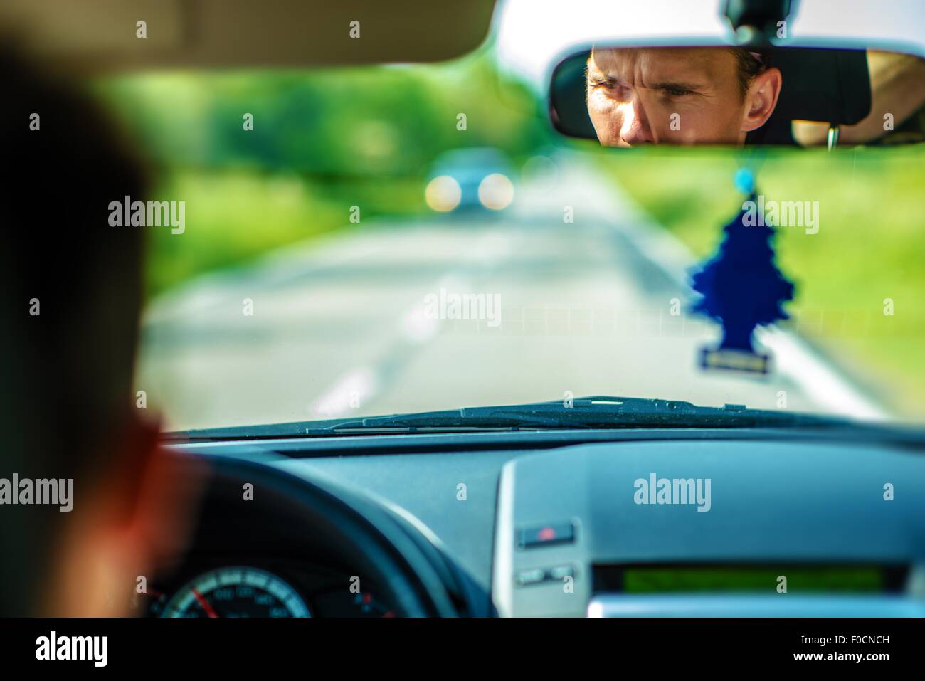 Pkw-Fahrer in einem inneren Spiegel. Fahren die Straße hinunter. Stockfoto