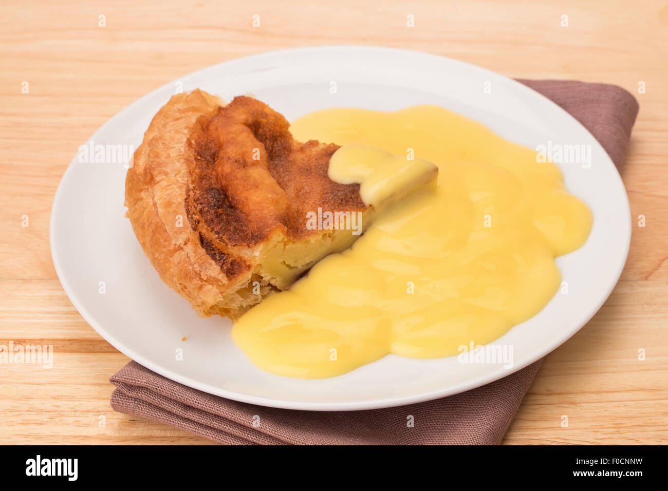 Eine traditionelle Derbyshire Bakewell Pudding und Vanillesauce Stockfoto