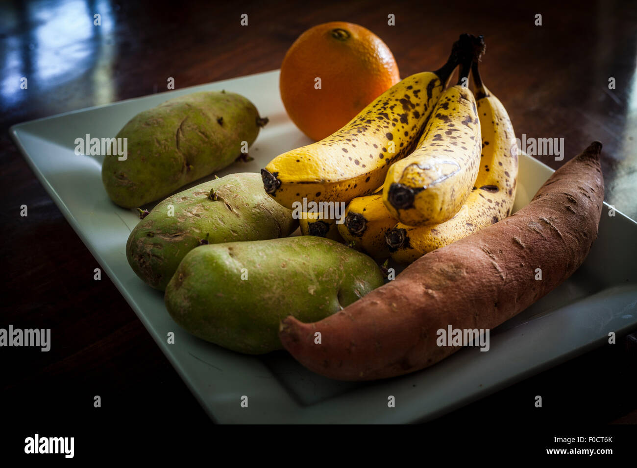 Eine Platte mit einige gesunden Entscheidungen darauf. Bananen Süßkartoffel orange und grüne Kartoffeln, die nicht gegessen werden sollte, bis gekocht Stockfoto