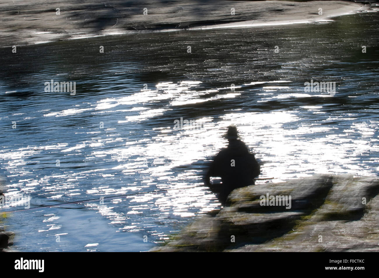 Mann sitzt auf einem Felsen Fischen, Fluss Orkla, Norwegen, September 2008 (Modell freigegeben) Stockfoto