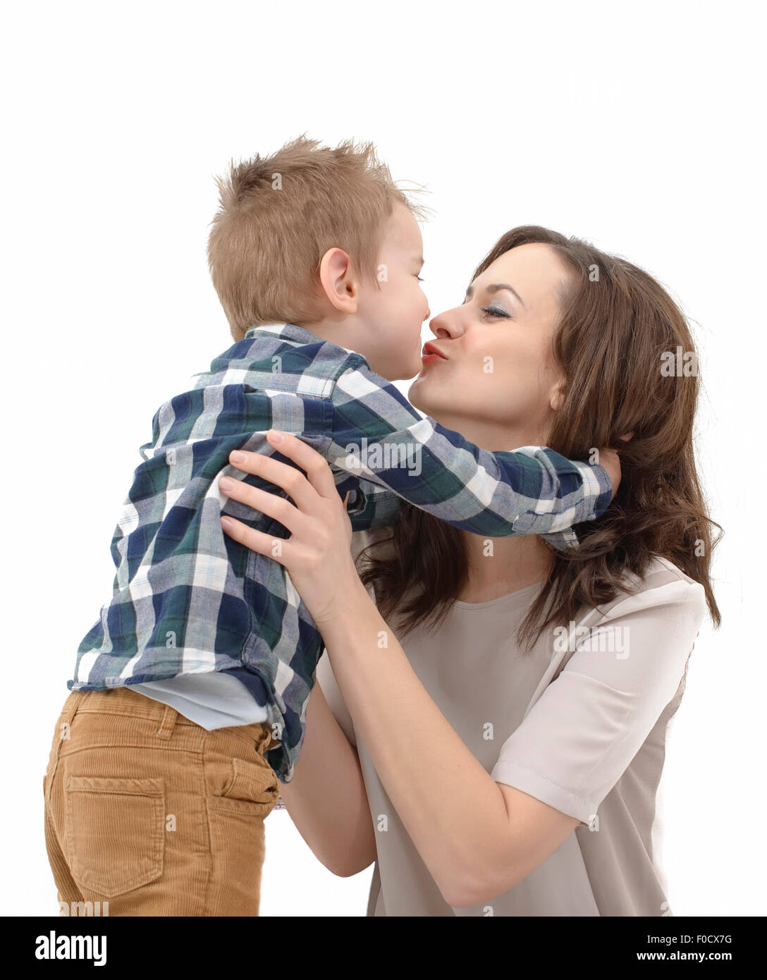 junge Mutter, die ihre kleinen Kinder küssen Stockfoto