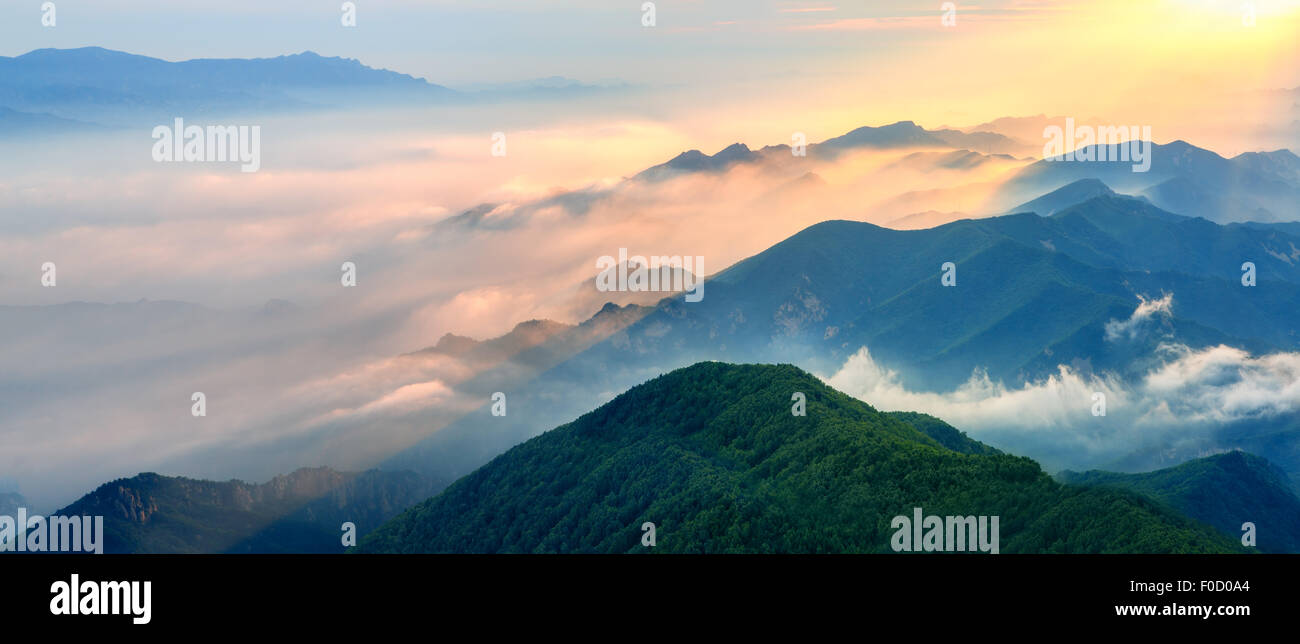 Nebelige Landschaft in den Bergen. Fantastische Morgen Glühen durch Sonnenlicht. Stockfoto