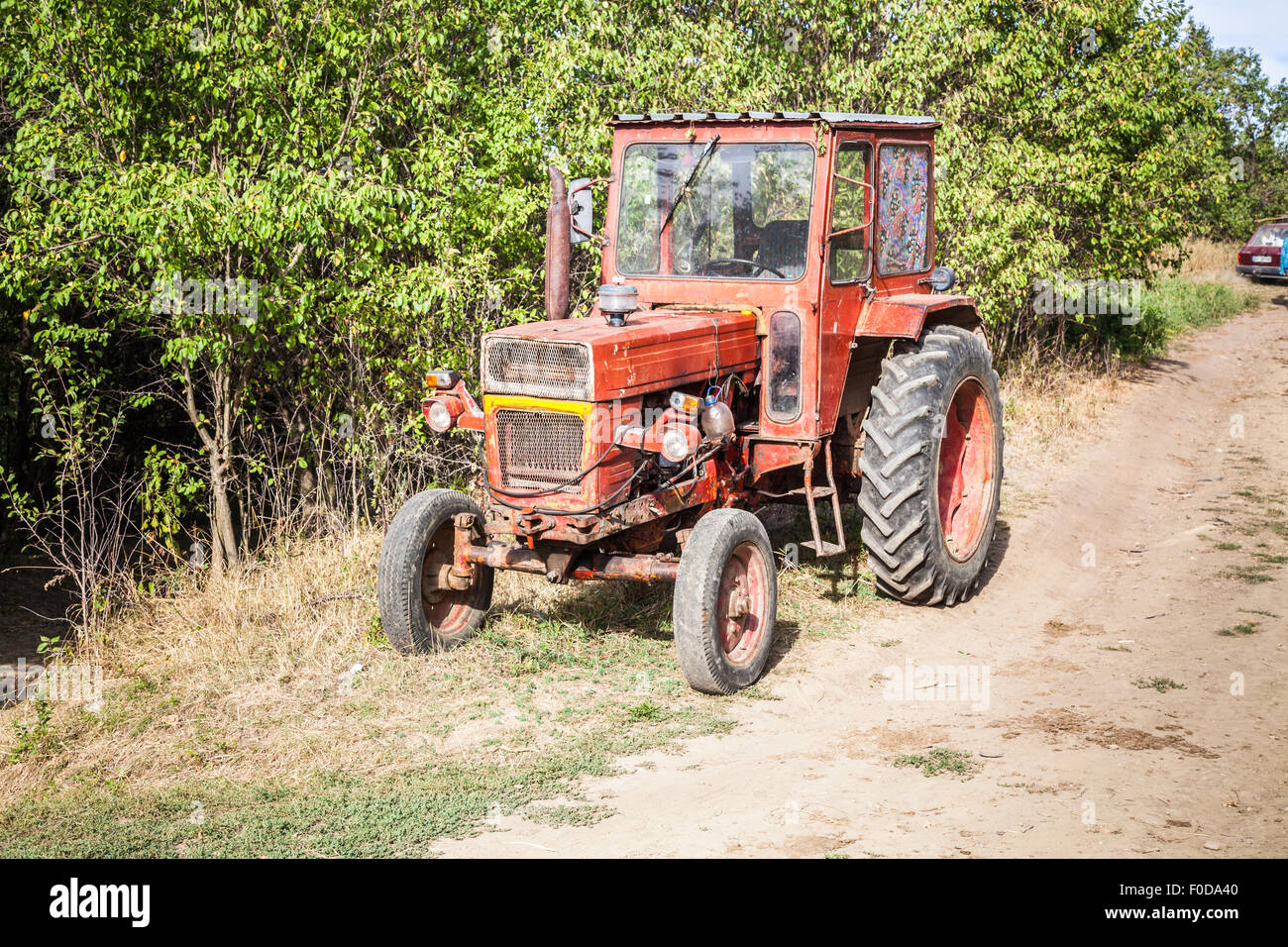 Typische altmodischer rote Oldtimer-Traktor geparkt am Straßenrand in der alten sächsischen Dorf von Deutsch-Weißkirch, Siebenbürgen, Rumänien, Osteuropa Stockfoto