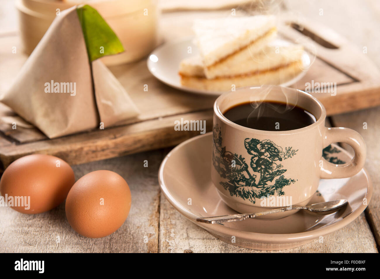 Traditionelle Kopitiam Stil malaysischen Kaffee in Vintage Tasse und Untertasse und Frühstück mit Morgensonne. Fraktal auf der Tasse ist Stockfoto