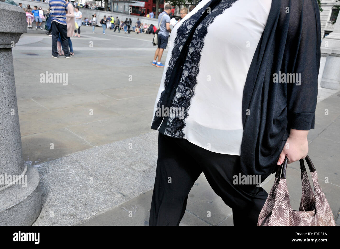 London, England, Vereinigtes Königreich. Übergewichtige Frau auf dem Trafalgar Square Stockfoto